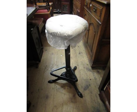 Modern cast iron circular stool with foot rest, together with a blue canvas travel trunk