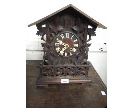 Black Forest cuckoo clock, having carved decoration and circular dial and Roman numerals, the two train movement striking on 