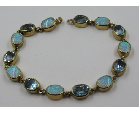 9ct Gold synthetic opal and blue topaz bracelet, gross weight 12gThere are general minor abrasions consistent with regular we