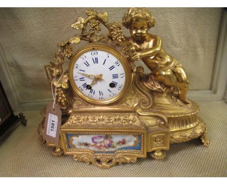 19th Century French ormolu mantel clock, the circular enamel dial with Arabic and Roman numerals, the case with bacchanalian 