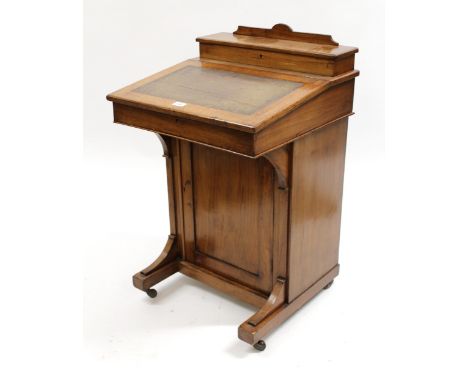 Late Victorian walnut Davenport with a stationery compartment and sloping top above a front panel door