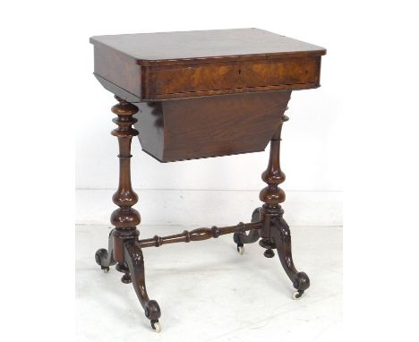 An Victorian walnut sewing table, with single drawer and sliding base, includes some sewing accessories, raised on ceramic ca