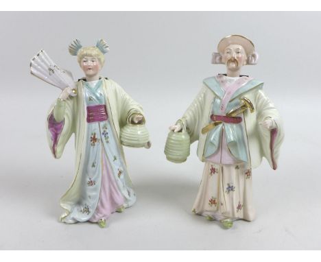 A pair of early 20th century Continental 'Nid Nod' ceramic figurines, modelled as a lady and gentleman in Oriental inspired a