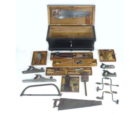 A vintage tool chest containing various woodworking and carpenters tools, including planes, chisels, saws and measures, some 