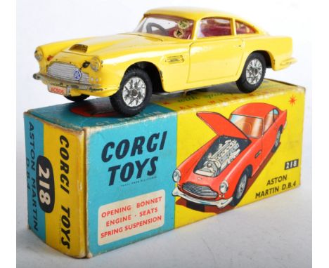 An original vintage boxed Corgi Toys diecast model car No. 218 Aston Martin DB4. Yellow bodywork with opening bonnet and spri