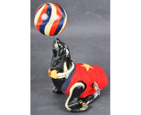 An original vintage Japanese made tinplate clockwork acrobatic seal and ball toy. Litho printed tin construction, with tinpla