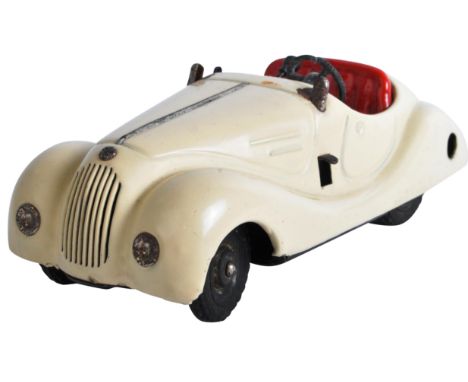 An original vintage German Schuco Examico 4001 tinplate wind-up clockwork model car. Cream body work with steering wheel and 