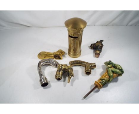 A small collection of walking stick handles and a brass money bank 