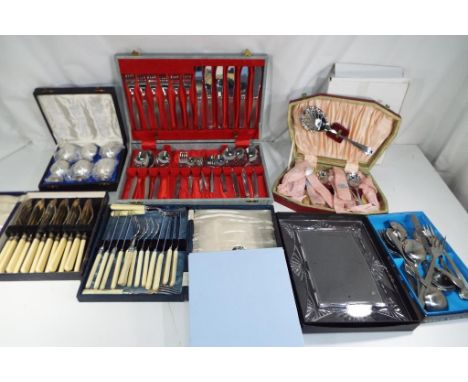 A cased set of vintage cutlery, a large quantity of plated flatware and three photograph frames, boxed