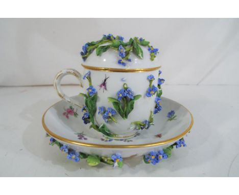 Meissen - a Meissen covered chocolate cup and saucer with hand painted decoration depicting flowers and insects with applied 