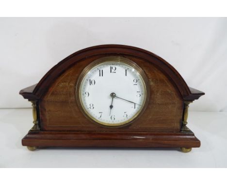 An Edwardian mahogany cased mantel clock, flanked by short brass baluster form columns and mounted on brass bun feet, 8-day p