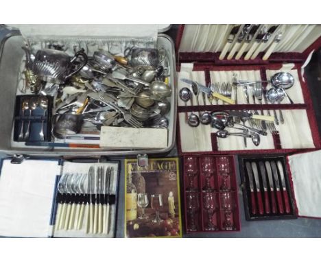 A vintage suitcase containing a quantity of plated flatware and similar.
