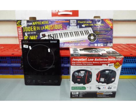 A Jumpstart battery charger by Powerstation in original box, a Homark ceramic plate heater and a Professional Evolution elect