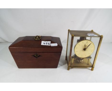A brass cased 400-Day or Anniversary clock by Kundo, unusual feature of the hands being accessible outside of the case for ea