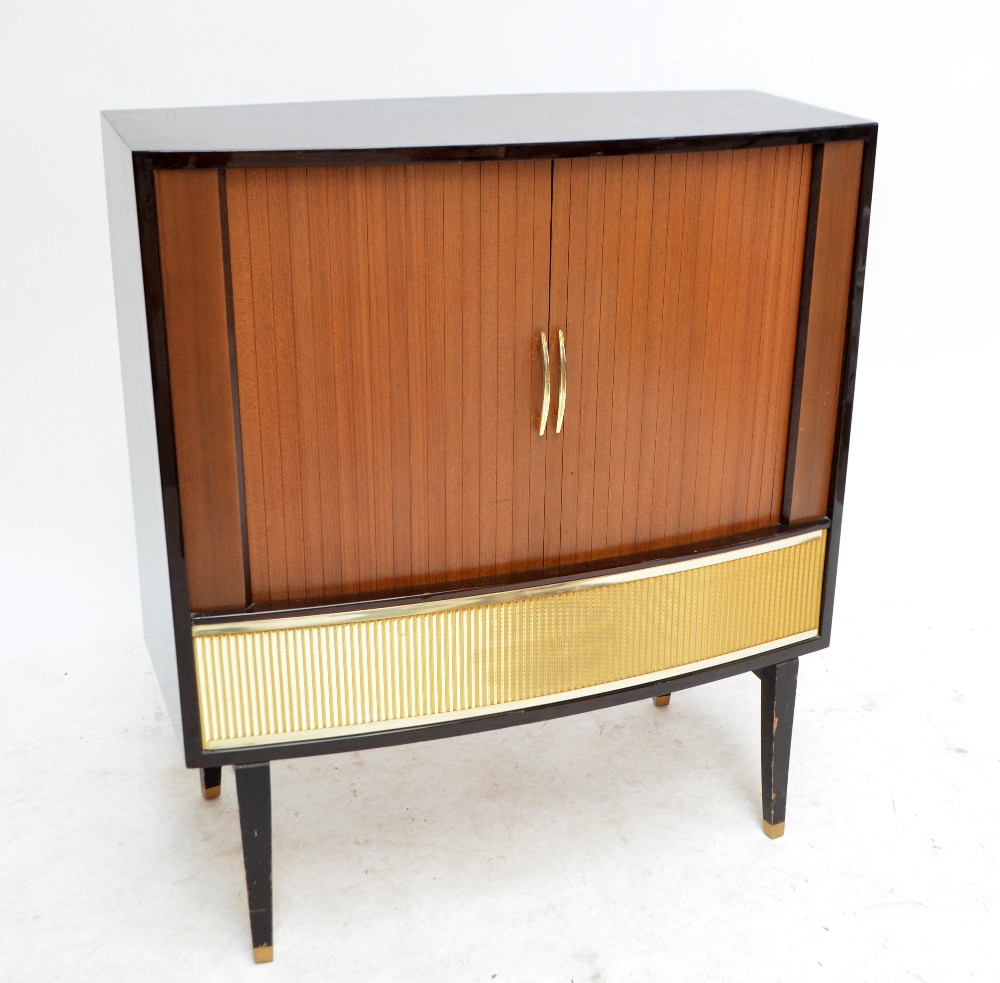 A vintage HMV television in with sliding tambour doors and raised on square sectioned tap