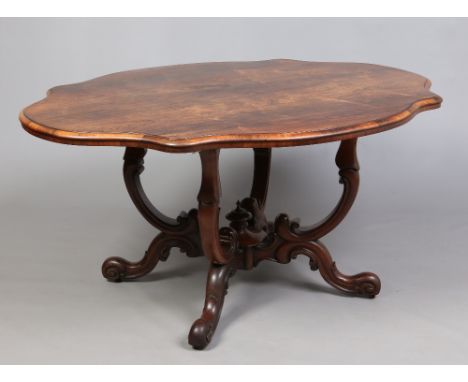 A Victorian rosewood centre table. With serpentine lozenge shaped top raised on a double scrolling openwork base, 154cm. Cond