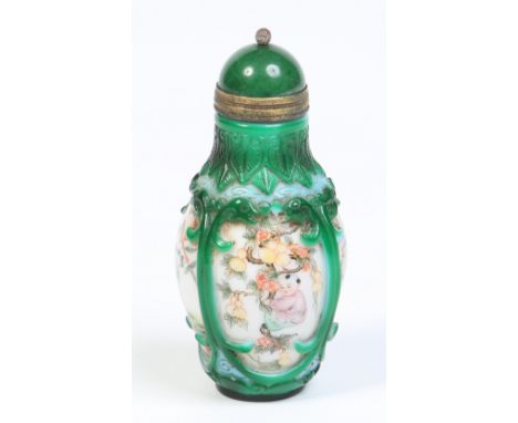 A Chinese opaque white glass snuff bottle with spinach jade stopper. Enamelled with figures of children collecting fruit and 