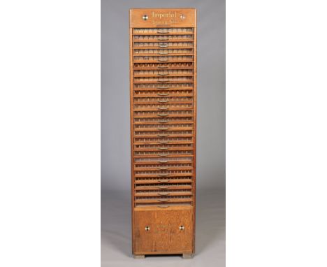 A vintage Imperial sewing silk advertising oak shop display cabinet formed as a bank of twenty seven drawers over a cupboard 