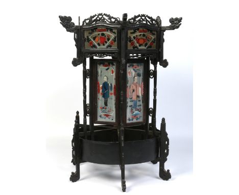 An early 20th century Chinese hexagonal carved hardwood lantern with open fret cresting, reverse painted glass panels and orn