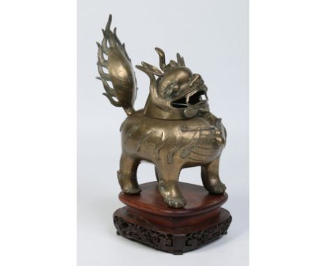 A 19th century Chinese bronze censor formed as a Kirin and raised on a carved and pierced hardwood plinth, 33cm.  Condition R