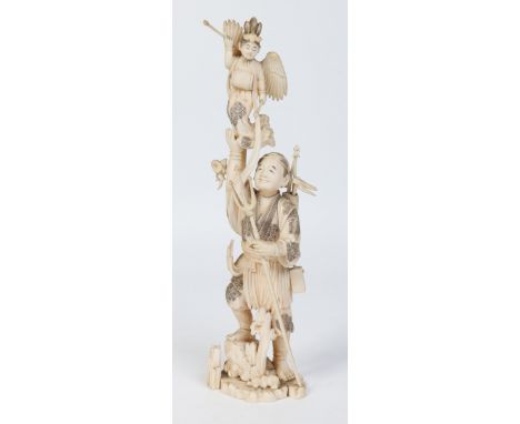 A Japanese Meiji period carved ivory okimono of a fisherman. Holding a trident in one hand and holding aloft a winged deity w