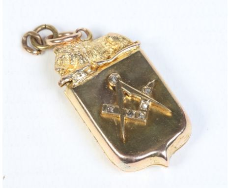 A Victorian yellow metal shield shaped locket surmounted by a lion and having a Masonic emblem set with rose cut diamonds. 10