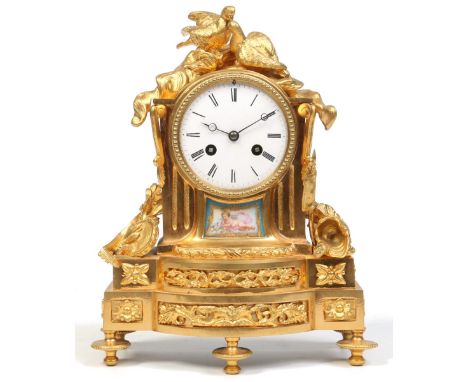A 19th century French gilt bronze mantel clock surmounted with a pair of birds, musical instruments and trophies of war. Havi