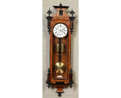 A 19th century walnut cased twin weight eight day Vienna wall clock. With ebonized mouldings, enamel dial incorporating subsi