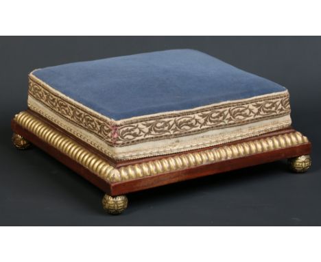A Victorian mahogany and parcel gilt upholstered foot stool raised on ormolu ball feet, 43cm square.