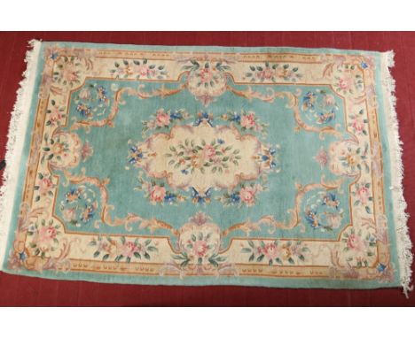 A 20th century Chinese wool carpet. Teal ground and decorated with flowers, 280cm x 186cm.  Condition Report. To be used as a