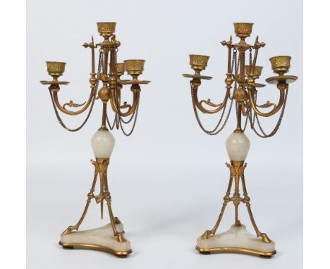 A pair of 19th century Neoclassical style gilt bronze and alabaster three branch candelabrum. Raised on hoof shaped feet over