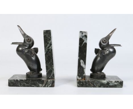 After Andre Vincent Becquerel, a pair of Art Deco silvered bronze bookends raised on verdi antico marble plinths. Formed as a