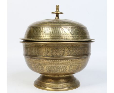 A 19th century large Islamic bronze bowl and cover. Engraved with bands of stylized foliage, 30cm. Condition Report. To be us