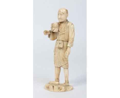 A Japanese Meiji period carved ivory sectional Okimono formed as a man with a double gourd flask and a parcel. Signed, 19.5cm