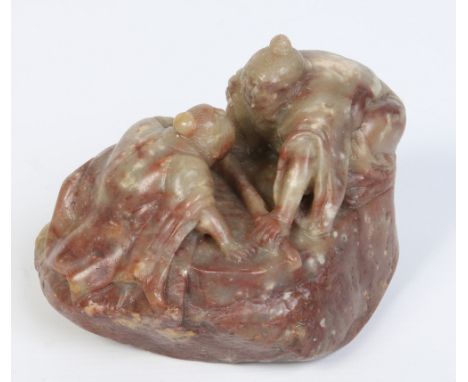 A Chinese soapstone boulder carving with jade and russet tones. Formed as a pair of crouching figures staring intently at one