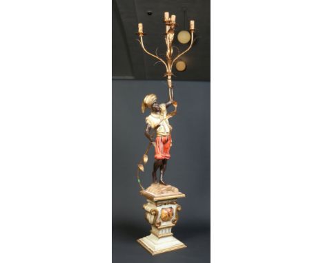 An early 20th century Continental carved polychrome wood Blackamoor lamp. The figure supporting a five branch gilt metal ligh