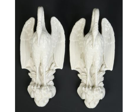 A pair of blanc de chine wall pockets in Royal Worcester style. Each formed as a heron perched on a naturalistic base moulded