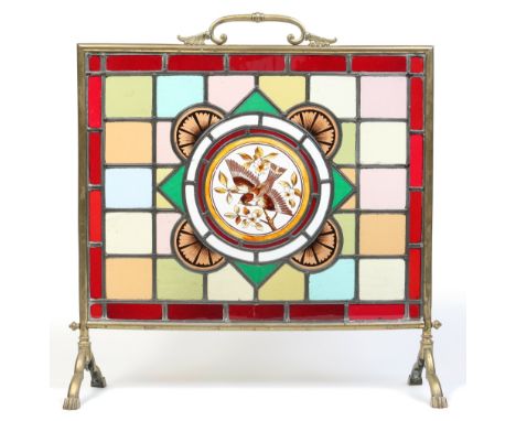 A Victorian brass firescreen with leaded, stained and painted glass panel. Decorated with a finch perched on a blossoming bra