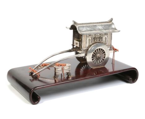 A late 19th / early 20th century Chinese silver jewellery casket on scroll shaped hardwood plinth. Formed as a horse drawn co