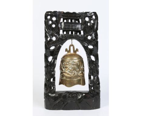 A 19th century Oriental bronze prayer gong raised on a carved and pierced hardwood stand with silver wire inlay, 44cm high.  