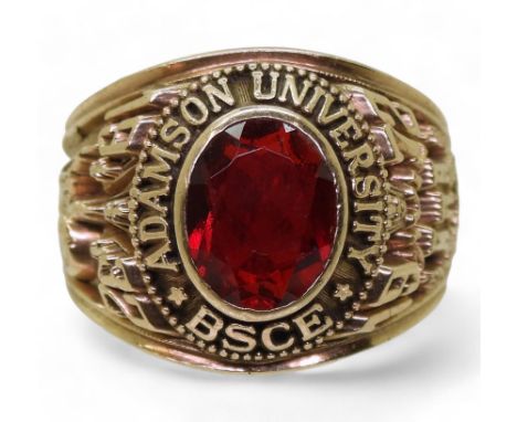 A Suarez brand American college ring, for Adamson University BSCE, 1972, made in yellow metal and set with a red glass gem. S