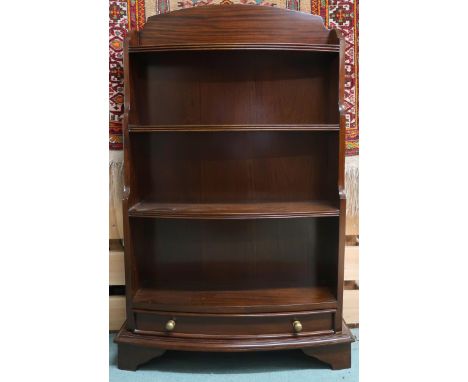 A 20th century mahogany bow front waterfall bookcase with three open shelves over single drawer on bracket feet, 111cm high x