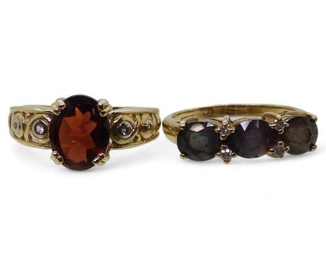 A 9ct gold ring set with three purplish colour change gemstones and diamond accents, size N1/2, and a 9ct gold garnet and dia