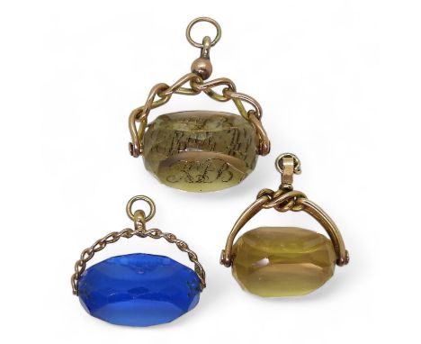 Three swivel fobs, an intaglio carved monogrammed citrine example in 9ct mount, a yellow glass example in a 9ct knot mount an