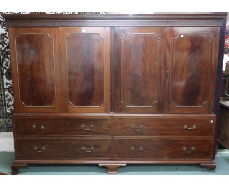 A large 20th century mahogany veneered linen press/wardrobe with dentil cornice over two pairs of panel doors right concealin