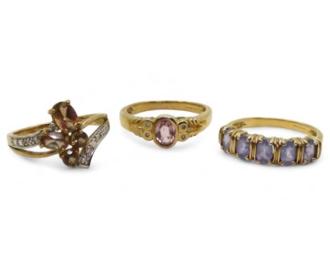 A 9ct gold andalusite and diamond accent cluster ring, size N1/2, a 9ct pink sapphire and diamond ring, size N1/2 and a purpl