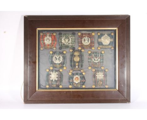 Framed display of Scottish Regiments cap badges, shoulder titles, tartans and buttons to include Highland Light Infantry, Roy