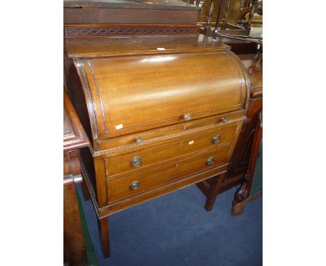 A SMALL EDWARDIAN MAHOGANY BARREL FRONTED DESK, with pull out writing area above two long drawers