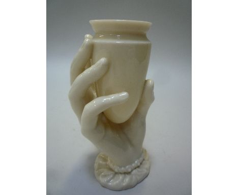 A ROYAL WORCESTER VASE, the vase supported in a hand, impressed marks, height 15.5cm