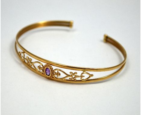 A BANGLE, with central amethyst with twisted fancy openwork design